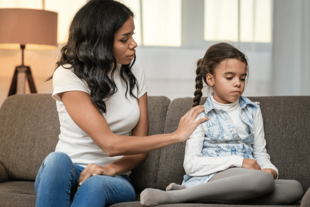 A mother talking to her young daughter at home.