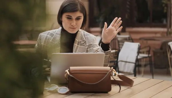 A woman speaking seriously with a licensed therapist via a laptop video call.